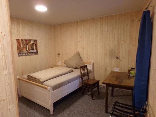 a small bedroom with a bed and a table at Zehnthof in Geldersheim