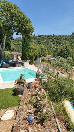 a garden with a swimming pool and some plants at Mon petit Eden in Le Muy