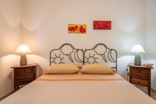 Un dormitorio con una cama grande con dos mesitas de noche. en Sapposentu de Dinu, en SantʼAnna Arresi