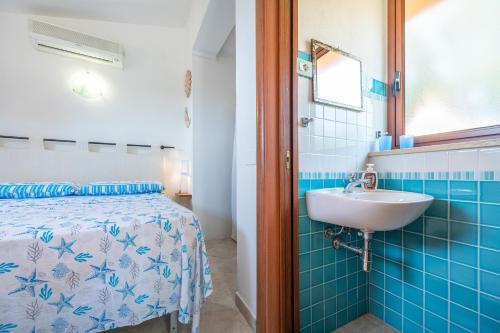 a bathroom with a bed and a sink at Casa Via del mare in Villasimius
