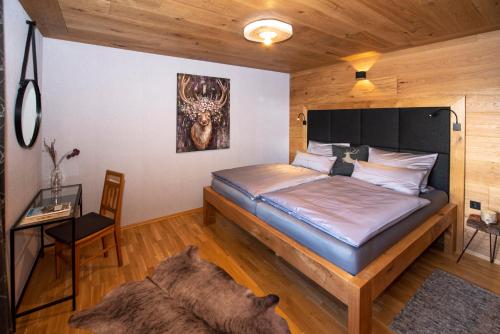 a bedroom with a bed and a desk in a room at Landhaus Bergheimat in Rauris