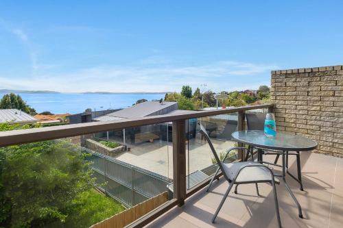 Kingston BeachにあるSelf Contained Beach View Apartmentのバルコニーにテーブルと椅子が置かれたパティオ