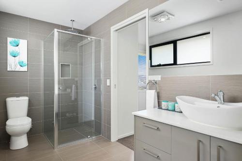 a bathroom with a shower and a sink and a toilet at Self Contained Beach View Apartment in Kingston Beach