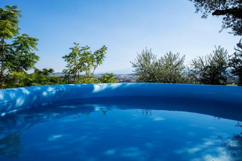 a pool of blue water with trees in the background at Borgo Case Lucidi relax in Torano Nuovo