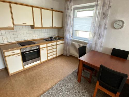a small kitchen with a wooden table and a dining room at Ferienwohnung am Obstgarten in Bad Bocklet