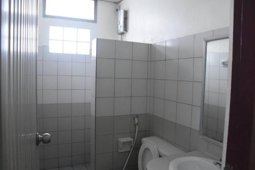 a bathroom with a sink and a toilet and a window at โรงแรมวัฒนาตรัง in Trang