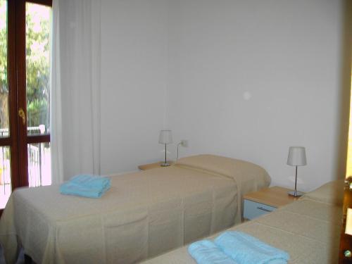 a bedroom with two beds and a window at Gli Ulivi in Budoni