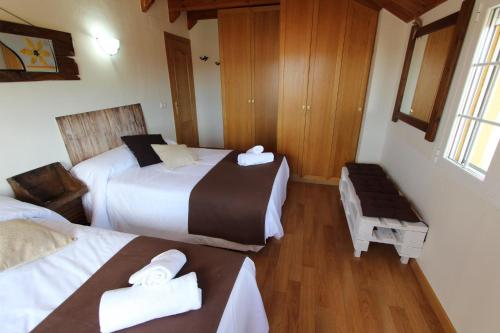 MuñecaにあるLas Riendas casa ruralのベッド2台とベンチ付きのホテルルームです。
