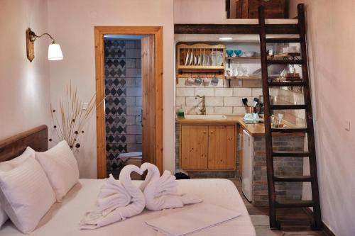 a room with two towels on a bed with a kitchen at kartalia studios in Porto Koufo