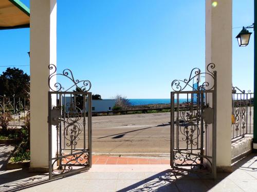 a pair of wrought iron gates with a view of the ocean at Hotel Porto Badisco in Porto Badisco