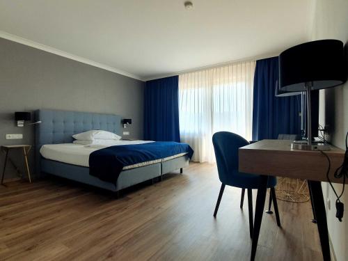 a bedroom with a bed and a desk and a desk at Hotel Räucherhansl in Loiching