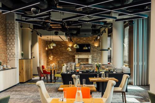 a restaurant with tables and chairs and a brick wall at ibis Styles Lublin Stare Miasto in Lublin