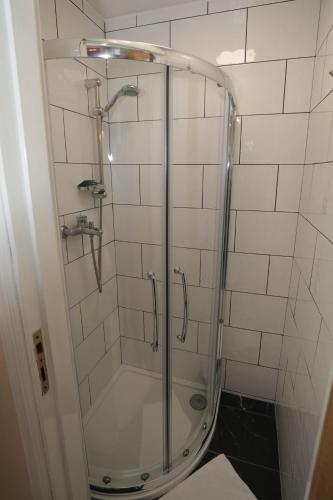 a shower with a glass door in a bathroom at Holland Inn Hotel in London