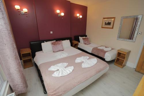 a room with two beds with towels on them at Holland Inn Hotel in London
