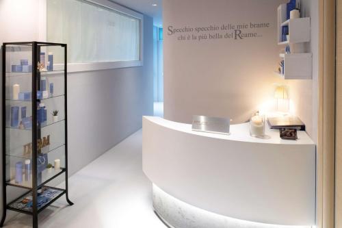 Una habitación blanca con un estante con velas. en Hotel Villa delle Fate, BW Signature Collection, en Sestola