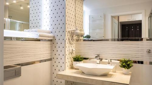 a bathroom with a sink and a mirror at VacationClub - ApartPark Albus Apartament 011 in Świnoujście