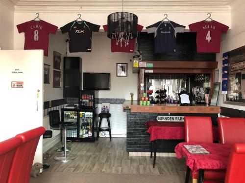 a bar withttenham shirts hanging on the wall at The Franklyn Hotel B&B in Blackpool