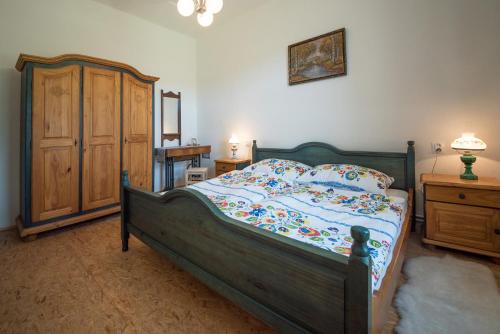Schlafzimmer mit einem Holzbett und einem Holzschrank in der Unterkunft Vopařilův statek Leština in Litomyšl