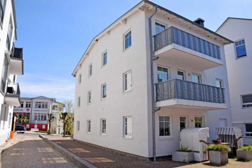 - un bâtiment blanc avec un balcon dans une rue dans l'établissement Appartementhaus Greta im Ostseebad, à Sellin