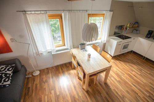 een woonkamer met een houten tafel en een keuken bij Das Nest am Park in Lemgo