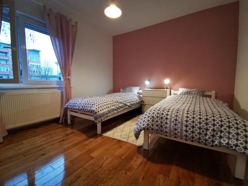 - une chambre avec 2 lits et une fenêtre dans l'établissement Angela Apartment, à Zagreb