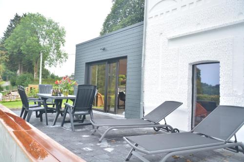 a patio with chairs and a table on a roof at Villa Charles in Francorchamps