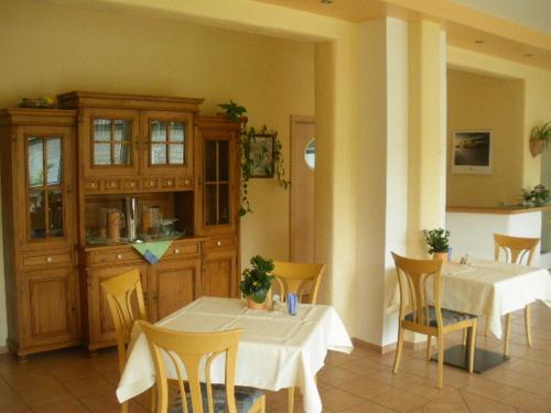 a dining room with two tables and chairs at Hotel Pit Lane "Home of Motorsport" in Nürburg
