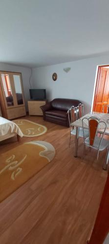 a living room with a table and chairs and a couch at Vila Diana in Vartop