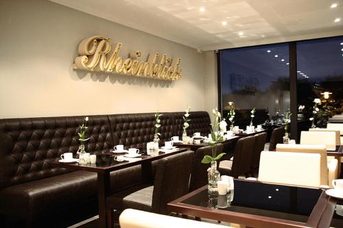 a dining room with tables and a sign that reads waitress at Villahotel Rheinblick in Cologne