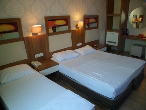 a bedroom with two beds and two lamps and mirrors at Hotel Baylan İzmir in Izmir