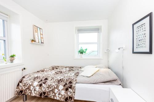 a small white bedroom with a bed and a window at In the heart of Tórshavn in Tórshavn