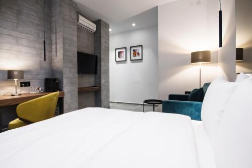 a hotel room with a bed and a desk at The Location Hotel in Belgrade