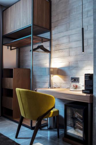 a kitchen with a yellow chair and a table at The Location Hotel in Belgrade