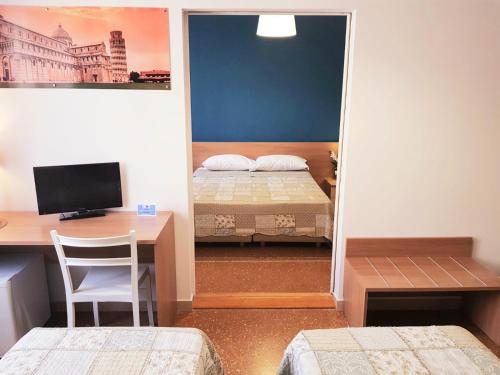 een slaapkamer met een bureau, een bed en een computer bij Bed and Breakfast Sognando Verso La Torre in Pisa