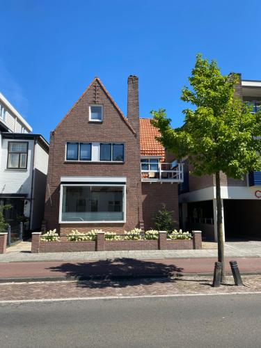 a brick house with a tree in front of a street at Studio Brinkstraat in Hoogeveen