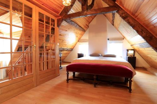 une chambre avec un lit dans une pièce avec des plafonds en bois dans l'établissement La maison au bord de l Aure, à Bayeux