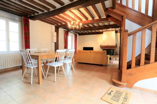 une salle à manger avec une table et des chaises en bois dans l'établissement La maison au bord de l Aure, à Bayeux