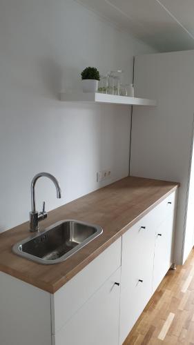 eine Küche mit einem Waschbecken und weißen Schränken in der Unterkunft Muziejaus 10 studija in Anykščiai