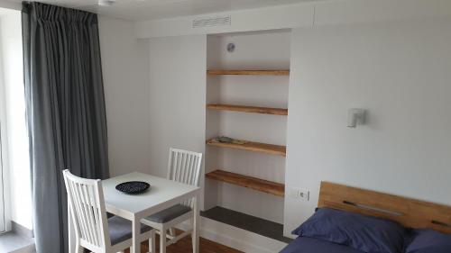 ein Schlafzimmer mit einem Tisch, einem kleinen Tisch und einem Bett in der Unterkunft Muziejaus 10 studija in Anykščiai