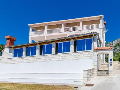 a large white house with a balcony at Villa Mateo with Private Pool in Gruda