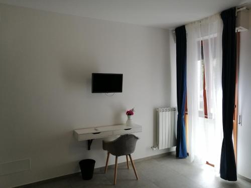Biały pokój z biurkiem i telewizorem na ścianie w obiekcie Bed and Breakfast My home w Pizie