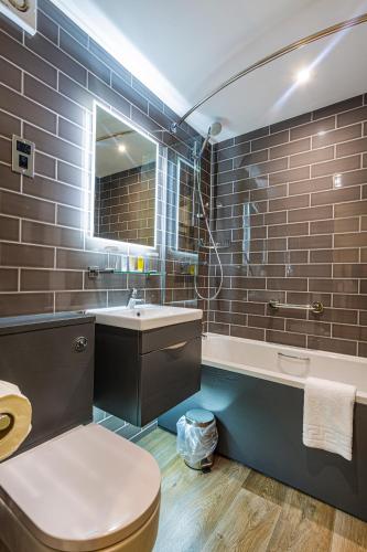a bathroom with a toilet and a sink and a tub at The Rutland Arms Hotel, Bakewell, Derbyshire - The Coaching Inn Group in Bakewell