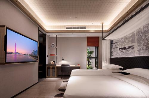 a bedroom with two beds and a flat screen tv at Arthur Hotel Zhujiang New Town Guangzhou-Free Shuttle Bus to Exhibition Centre during Canton Fair in Guangzhou