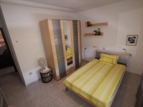 Dormitorio pequeño con cama y espejo en Entre pinos y playa, en Matalascañas