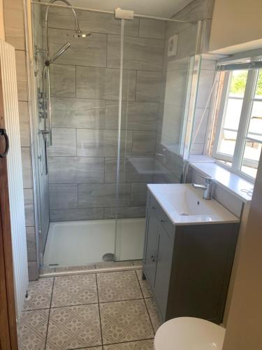 a bathroom with a shower and a sink and a toilet at Barlow Country Club - Mill Farm Cottages in Dronfield