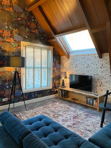 a living room with a blue couch and a tv at Slot Oostende in Goes