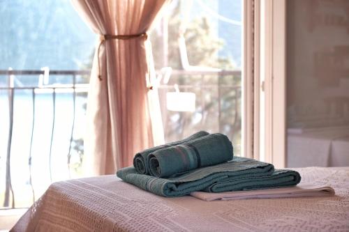 een stapel handdoeken bovenop een bed bij Kartalia apartment in Porto Koufo