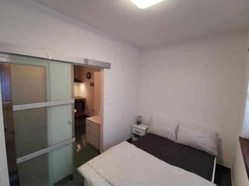 a small bedroom with a bed and a closet at Goriška Apartments in Ajdovščina