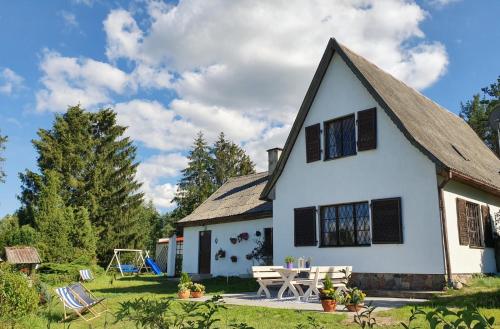 een wit huis met een picknicktafel in de tuin bij Villa Ardea in Konarzyny