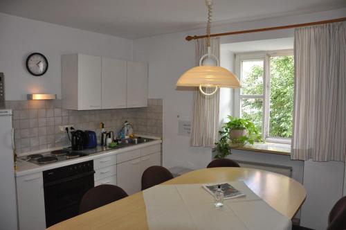 
a kitchen with a table, chairs, and a refrigerator at Katholische Akademie in Regensburg
